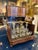 A liqueur cabinet with a drop-down lid made of burl walnut, featuring light wood marquetry bands forming a geometric...
