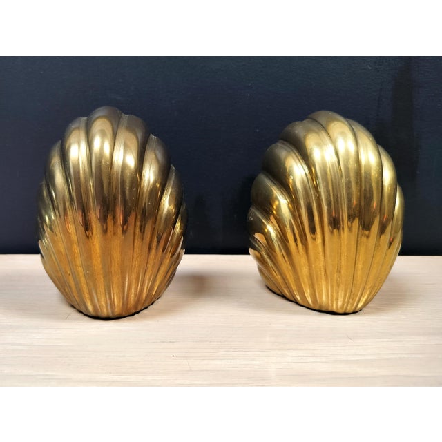 Solid brass scalloped bookends. Nice heavy construction with shiny brass. Felt on bottom. Circa 1970s. Each measures:...