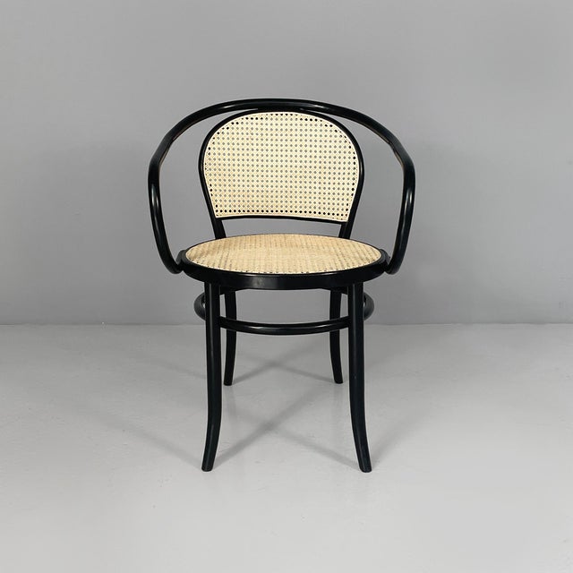 Italian modern chairs in straw and black wood, 1970s Set of eight chairs with straw seats and backs. The frame, armrests...