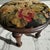An exceptional antique footstool featuring a beautifully, hand-stitched wool gros point top with a detailed floral motif....
