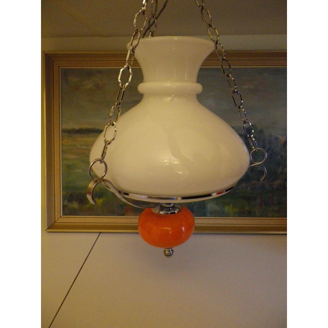 Beautifully finished, this pendant light features an orange glazed ceramic globe that gives it all its charm. 1970s...