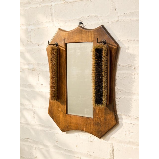 A wonderfully unusual antique grooming mirror featuring a warm wood frame and two original hanging clothes or grooming...