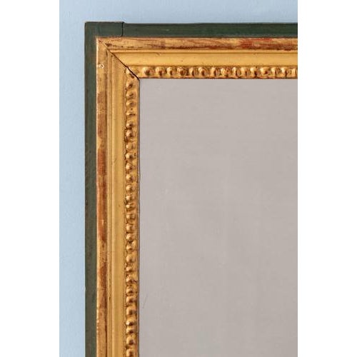 A late 18th-century French gilt gesso mirror in the Louis XVI style. Of compact rectangular form, the mirror is framed by...