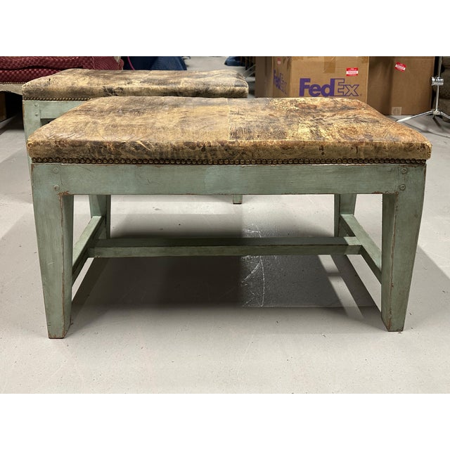 A wonderful pair of distressed leather top painted benches we purchased from a diverse Palm Springs estate. The estate...