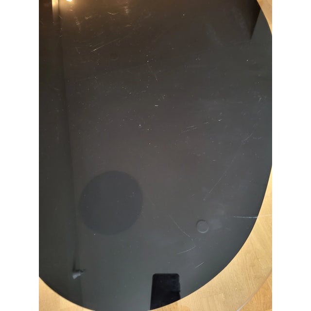 Vintage glass table with clear glass 2 in border which follows black inner shape. Glass is 1/4 in thick. 3 wooden...