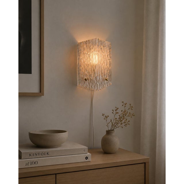 Thick pressed glass with a deep vertical striated texture — when lit, the surface catches and scatters light in shifting,...
