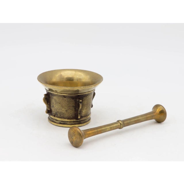 This early 20th-century mortar and pestle is made of brass with an honest patina. Both the mortar and pestle are...