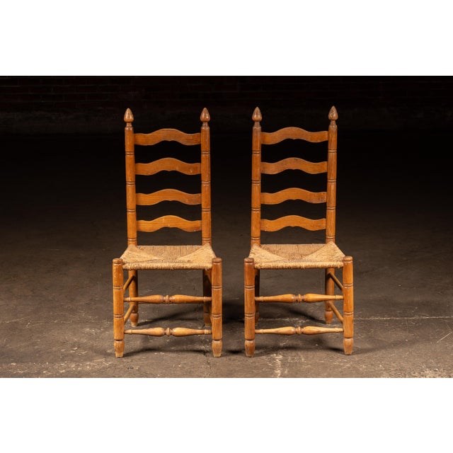 Pair of classic ladderback dining chairs constructed of hardwood with turned posts, tapered feet, and handwoven rush...