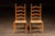 Pair of classic ladderback dining chairs constructed of hardwood with turned posts, tapered feet, and handwoven rush...
