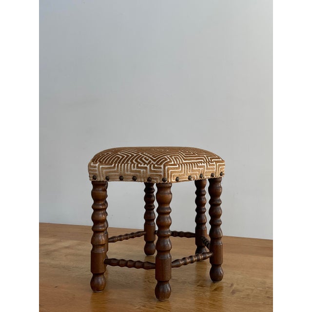 Elevate your interior with this striking vintage hexagonal footstool, a perfect blend of architectural form and plush...