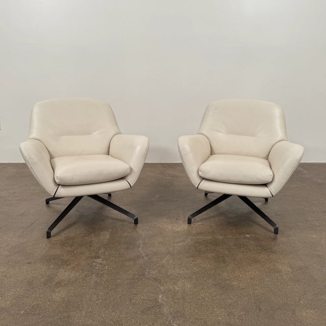 Discover timeless comfort in this Minotti Jensen Swivel Chair, upholstered in soft bone-colored leather that combines...