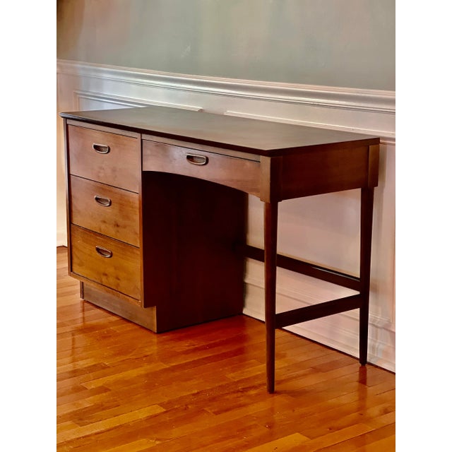 Vintage classic midcentury Lane walnut desk. The desk features atomic tapered legs, veneered wood grain laminate top and...