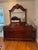 A traditional cherry-finish triple dresser with its attached arched mirror, from a four-piece carved bedroom suite. Seven...