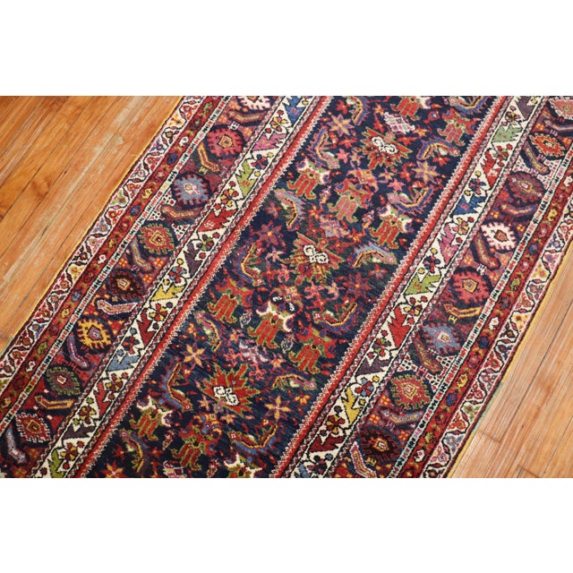 A traditional navy field Persian Malayer runner from the early 20th century. Measures: 3'4” x 15'4”.