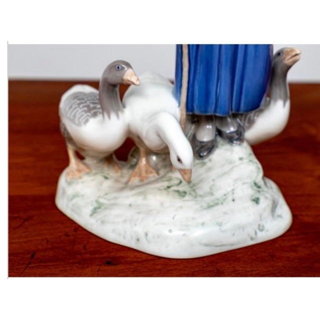 A charming vintage Bing & Grøndahl porcelain figural sculpture, “Girl With Geese,” designed by Danish sculptor Axel...