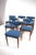 Set of six low-back Danish dining chairs featuring teak frames and a blue fabric upholstery. They are characterized by...