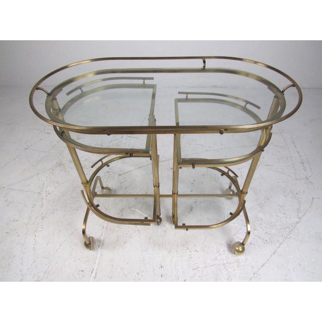 Unusual three-tier service/bar cart with fluted rails and glass shelves that swivel to open at various positions revealing...