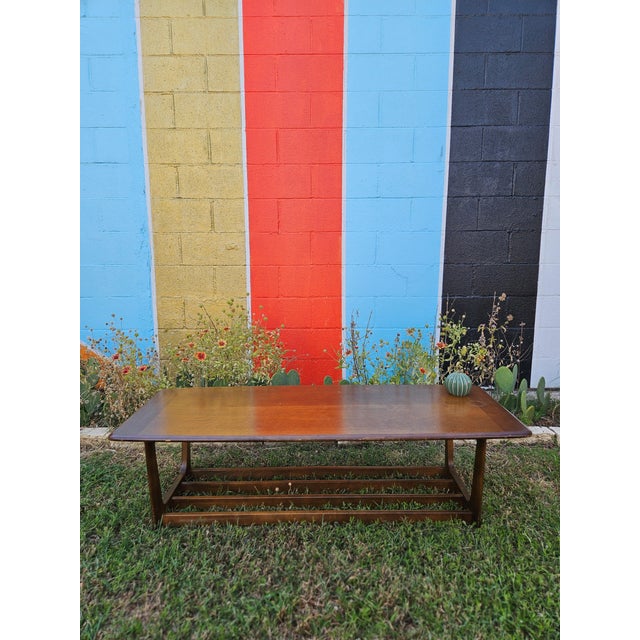 Classic mid-century modern surfboard coffee table featuring a long, low rectangular profile with rounded edges, warm...