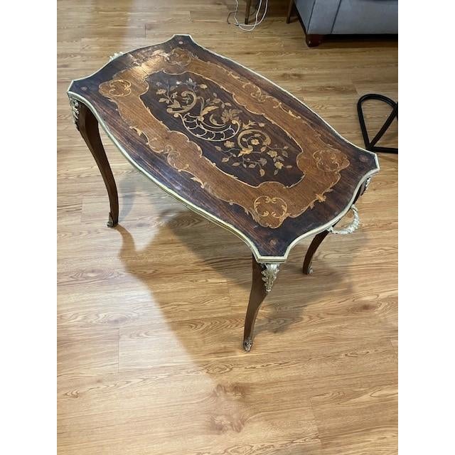 Brass ormolu mounts and intricate marquetry give this Edwardian Tea Table an elegant old world charm. Cabriole legs...