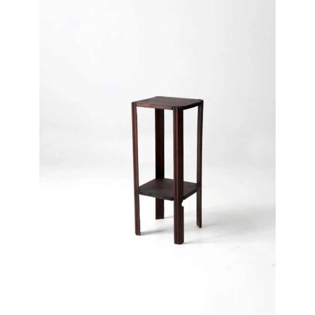 This is an antique Arts & Crafts plant stand circa early 20th century. The hand-crafted wooden stand features clean lines...