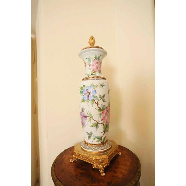 Large vase hand-painted with floral decor. The vase is complemented by polished brass mounts. Excellent condition. Signed...