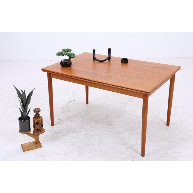 Vintage teak dining table with clean lines and a beautiful, warm teak grain. Thanks to the two extension leaves, the table...