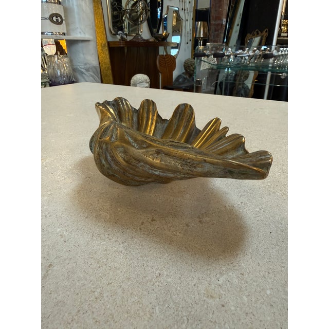 Charming vintage brass dish designed in the form of a scallop shell, featuring beautifully fluted ridges and a naturally...