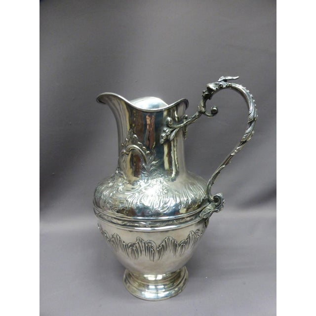 Baluster ewer and its basin in silver plated metal decorated with rocaille cartouche and moved frieze. Note that the ewer...