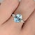 A sky blue aquamarine sits in a clear sea-blue at the heart of this solid 14K white gold ring, flanked by fifty-eight...
