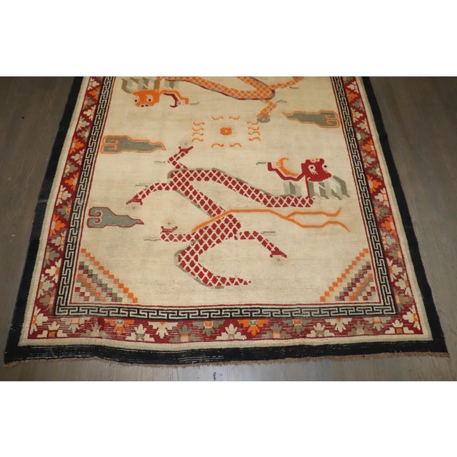 a mid-20th-century Dragon Design Ivory ground Tibetan Rug Details rug no. j4586 size 5' 11" x 7' 7" (180 x 231 cm) rug...