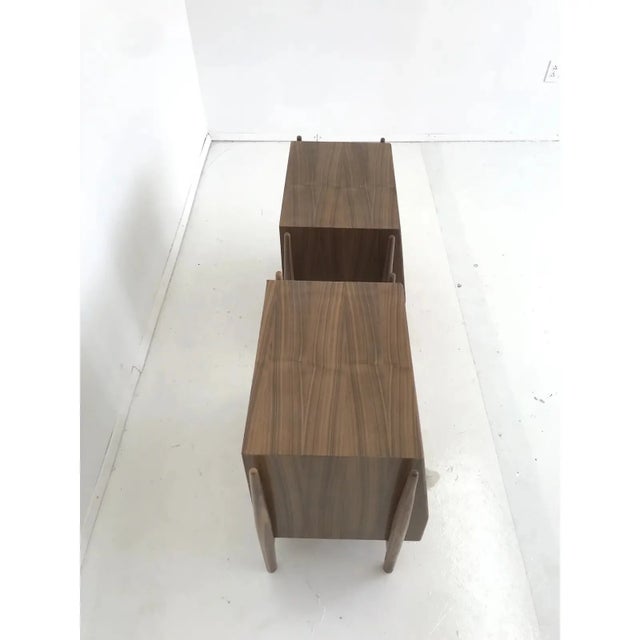 Contemporary pair of nightstands in the style of Kipp Stewart, handcrafted in solid and walnut veneer. This pair shows...