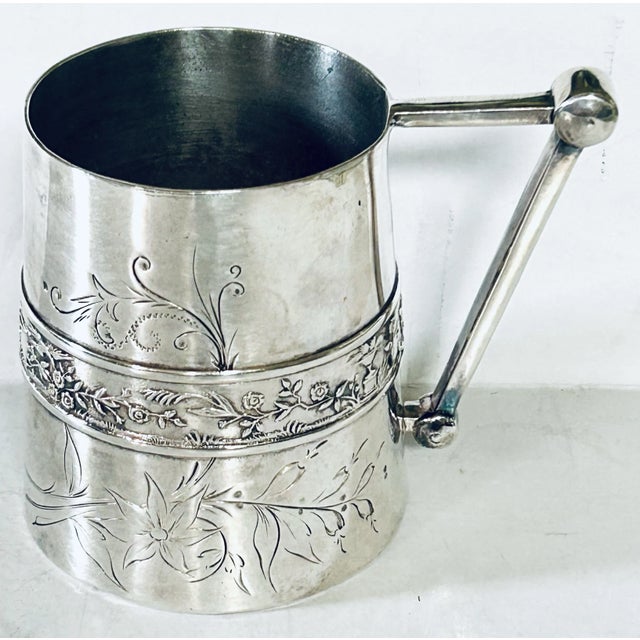Meriden quadruple silver plate mug/tankard with engraved floral pattern surround and raised middle band. Handle fashioned...