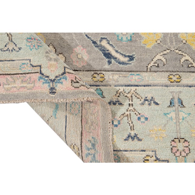 Beautiful contemporary Oushak hand-knotted wool rug with a Gray field. This rug has a frame of blue, pink, and multi-color...