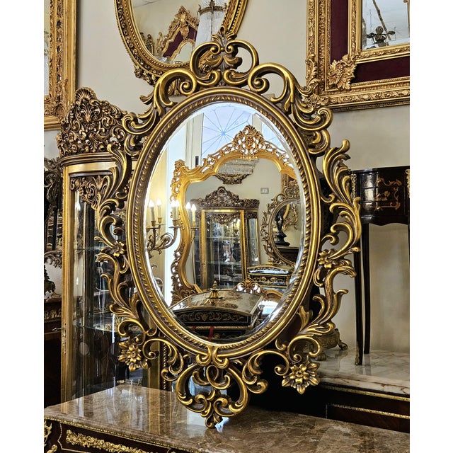Make a striking statement with this grand French Rococo–style oval mirror, featuring an exceptionally ornate frame covered...