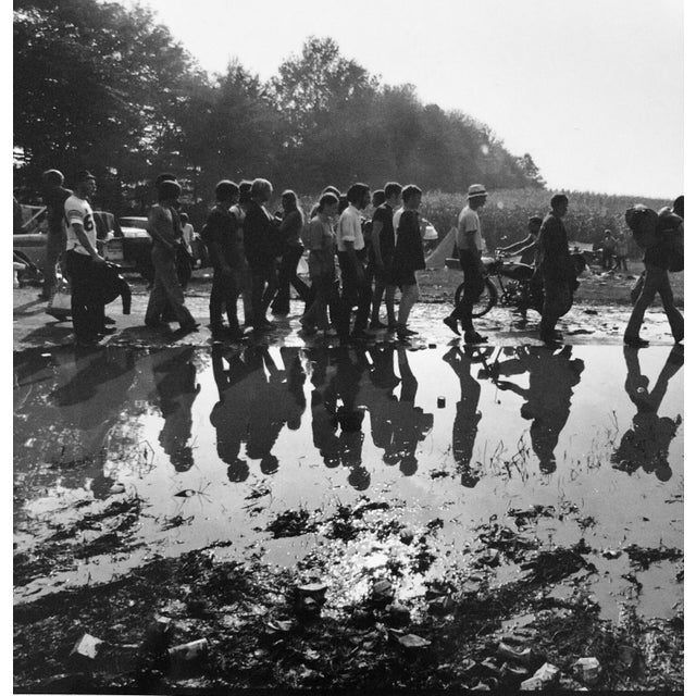 People walking alongside puddle at Woodstock in Bethel NY - 1969 Photographer is Fred McDarrah Over a 50-year span,...