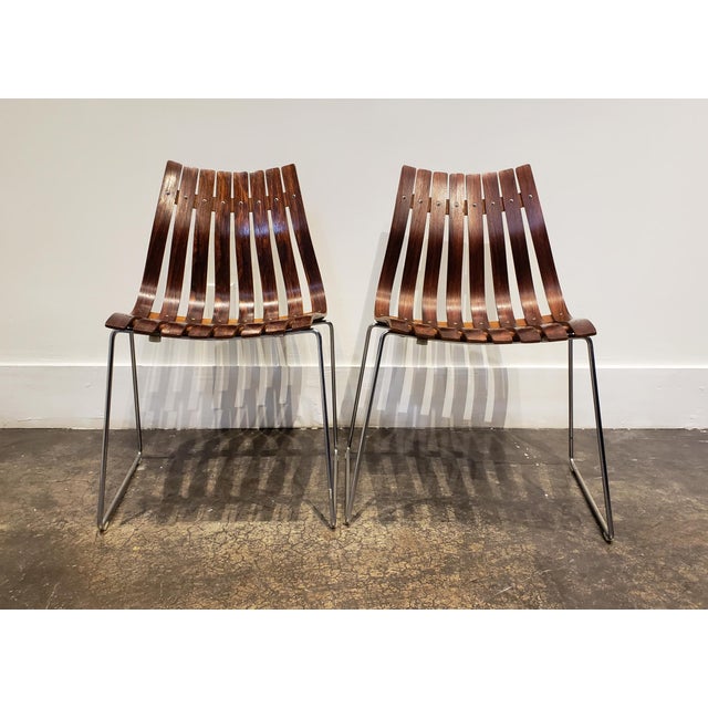 Sleek Mid-century slat chairs in beautiful Rosewood. Light elegant design with beautiful curves. Rosewood slats on metal...