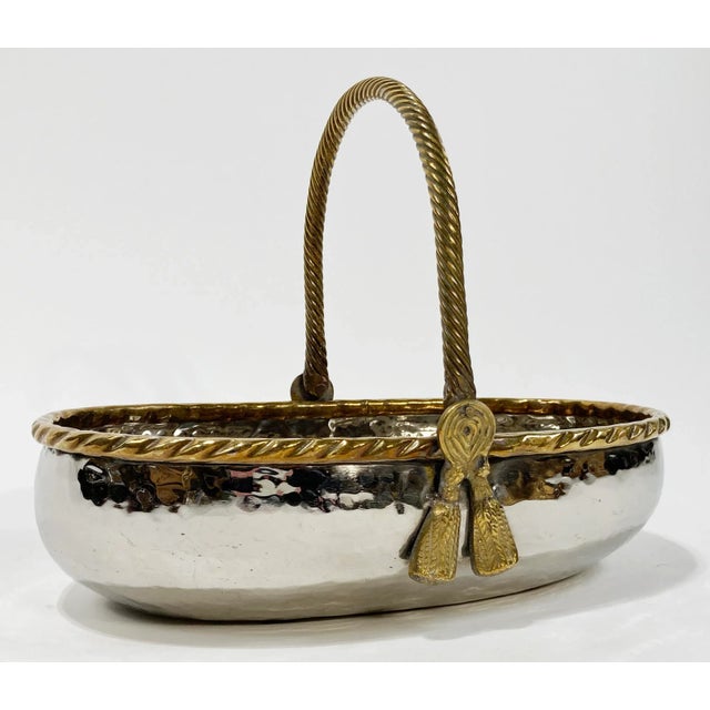 Stunning vintage decorative bowl made of heavy hammered silver metal with a brass rope detail framing the top. Handle is...