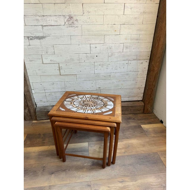 A stunning set of Danish teak nesting tables crafted by Mobelfabrikken Toften during the 1960s. Featuring warm brown teak...