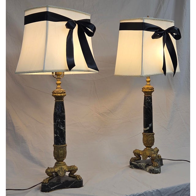 A beautiful vintage circa 1950s French empire neoclassical style marble and gilt bronze pair of table lamps styled with...