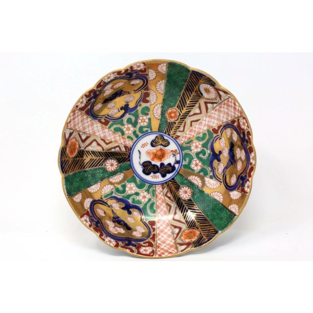 A nicely hand-painted and colored Japanese porcelain bowl, with scalloped edges, three-footed base, and extensive...
