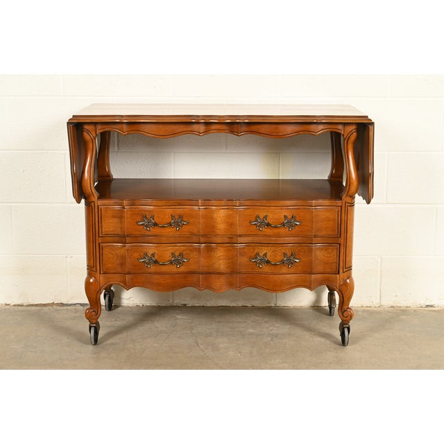A beautiful French Provincial Louis XV style drop leaf buffet server or bar cart By Thomasville USA, Circa 1970s Carved...