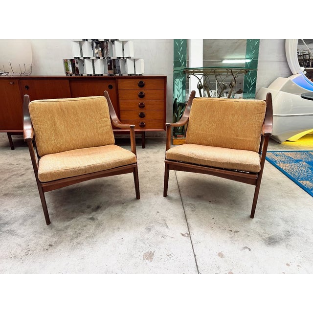 For sale is a pair of vintage scandinavian-style armchairs from the 1960s, featuring soft, enveloping lines. solid teak...