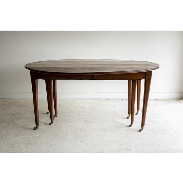 An elegant late-18th century French Directoire dining table crafted from richly figured walnut, embodying the restrained...