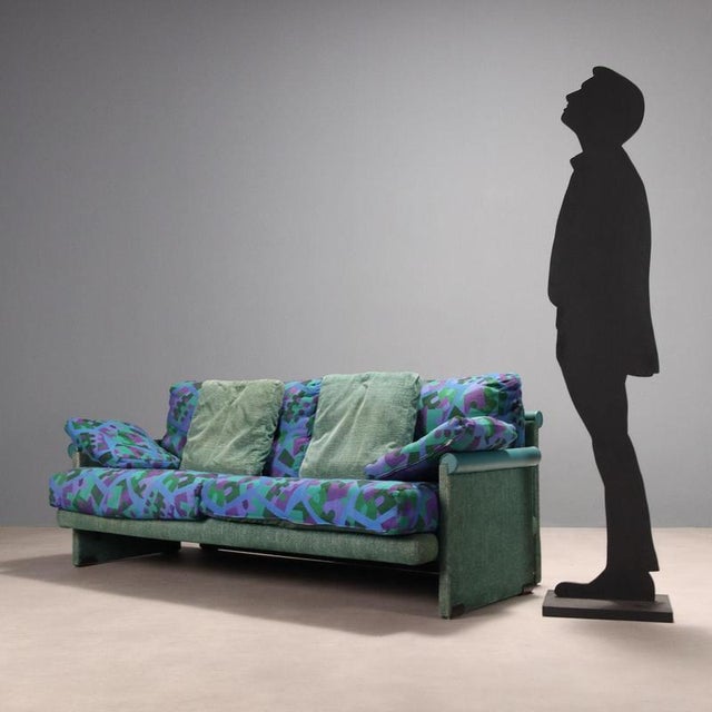 Vintage two-seater sofa with original period patterned fabric and a pair of turquoise cushions and two others in the same...