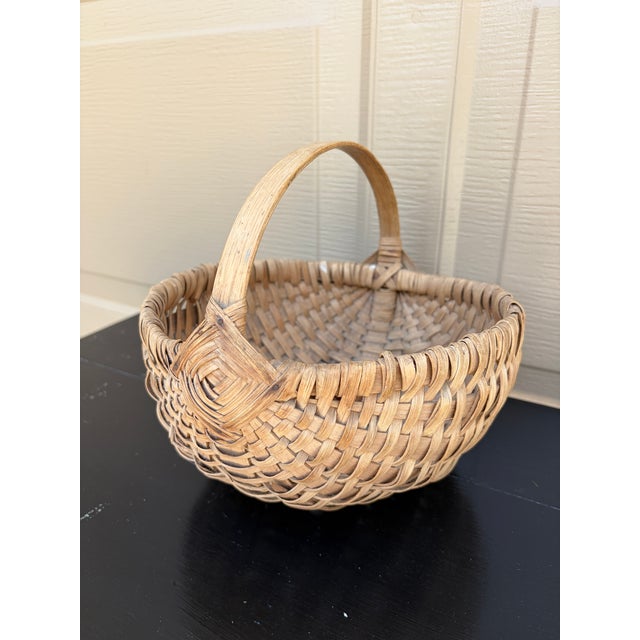 A beautifully woven early 20th century American splint oak basket with warm honeyed tones and a tightly constructed...
