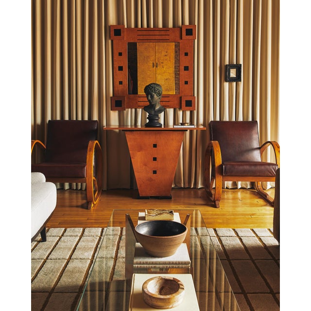 A striking Art Deco console and mirror set featuring warm-toned wood contrasted with bold black geometric inlays. The...