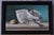 This oil on panel artwork presents a meticulously arranged still life featuring crumpled newspaper, a smooth stone, and a...
