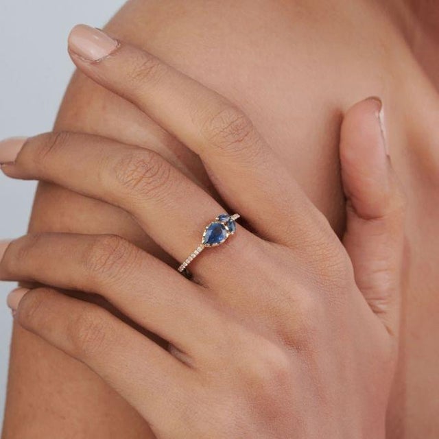 This contemporary bypass ring features 1.03 ct of a striking pear-shaped blue sapphire, set in 14k yellow gold. The pear-...
