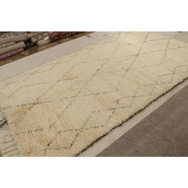 Hand-knotted in wool circa 1950-1960, this 6x11 vintage Moroccan rug is similar to Beni Ourain rugs in its minimalist...