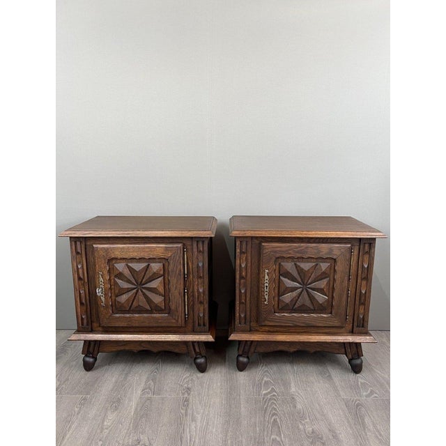 An elegant pair of small solid wood side tables dating from the early 20th century. Each piece features a front adorned...